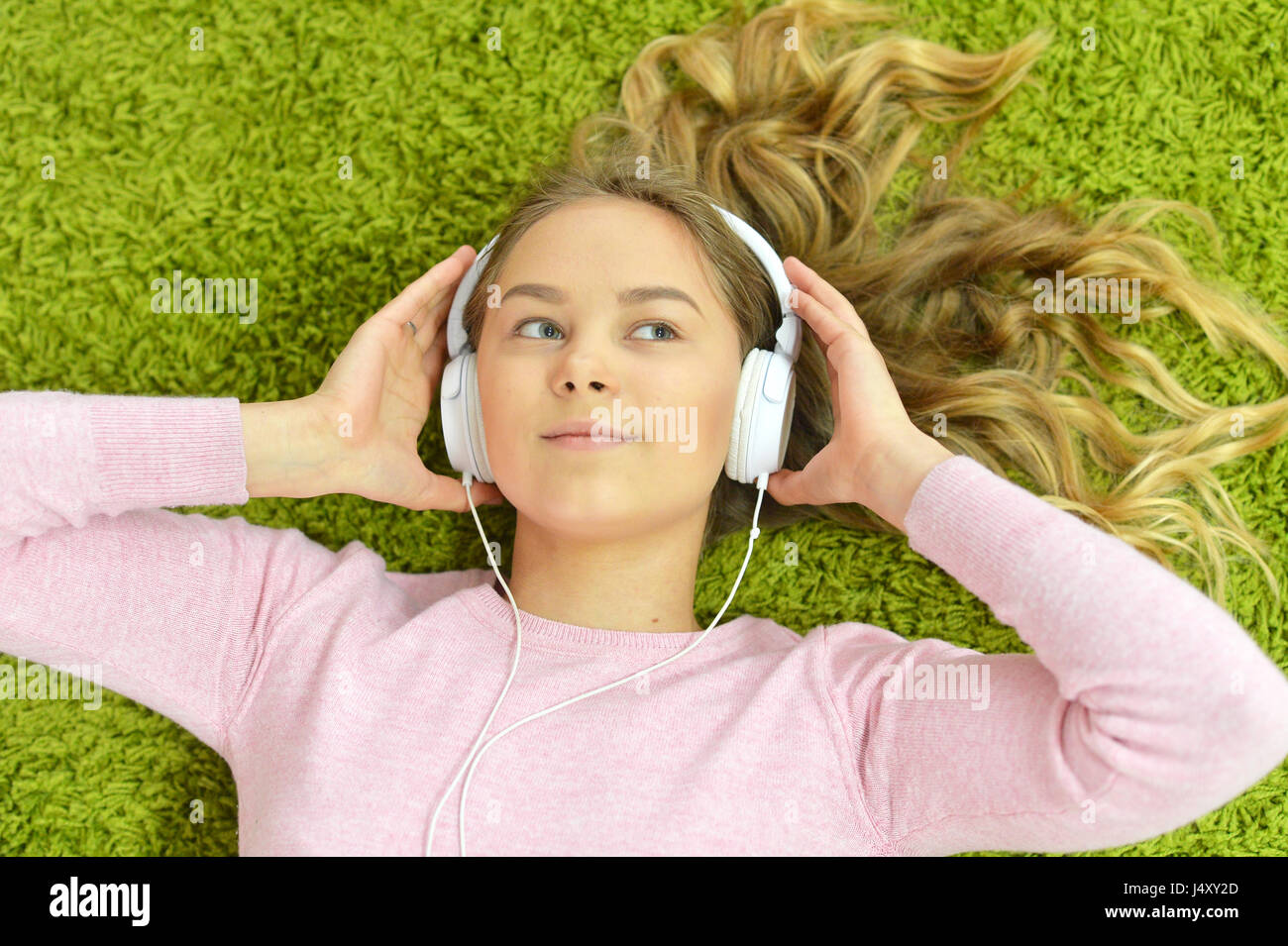 Girl lies on the floor and listens to music Stock Photo - Alamy