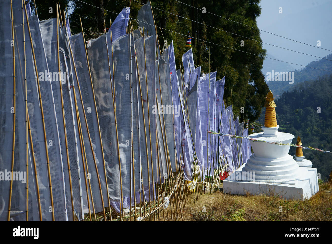 White prayer flags, symbolizing mounrning of dead with Buddhist stupa, Sangkak Choeling monastery, Yuksom Stock Photo