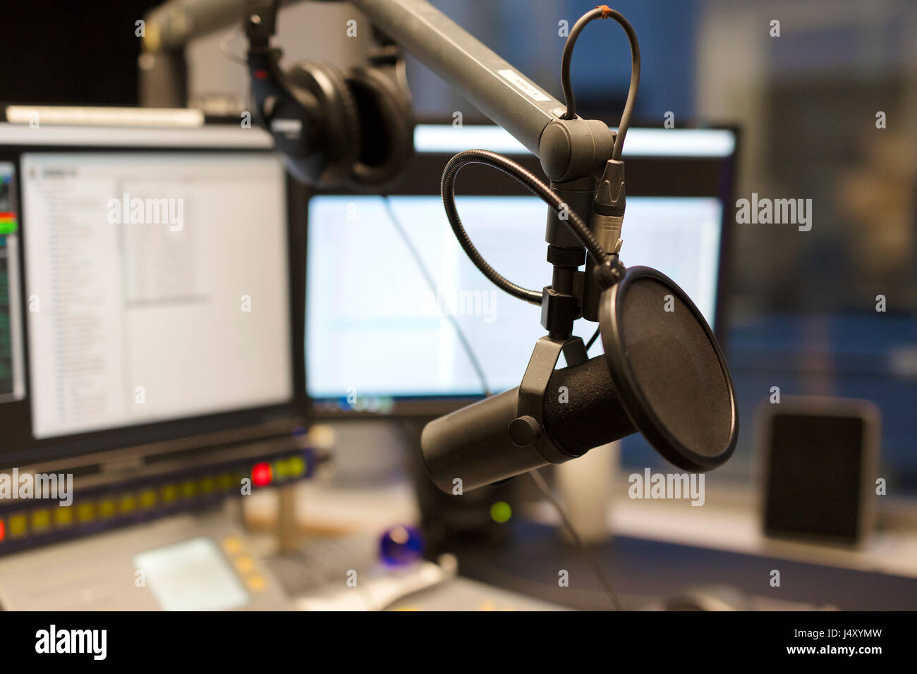 Studio microphone in front of radio station broadcasting equipment Stock Photo