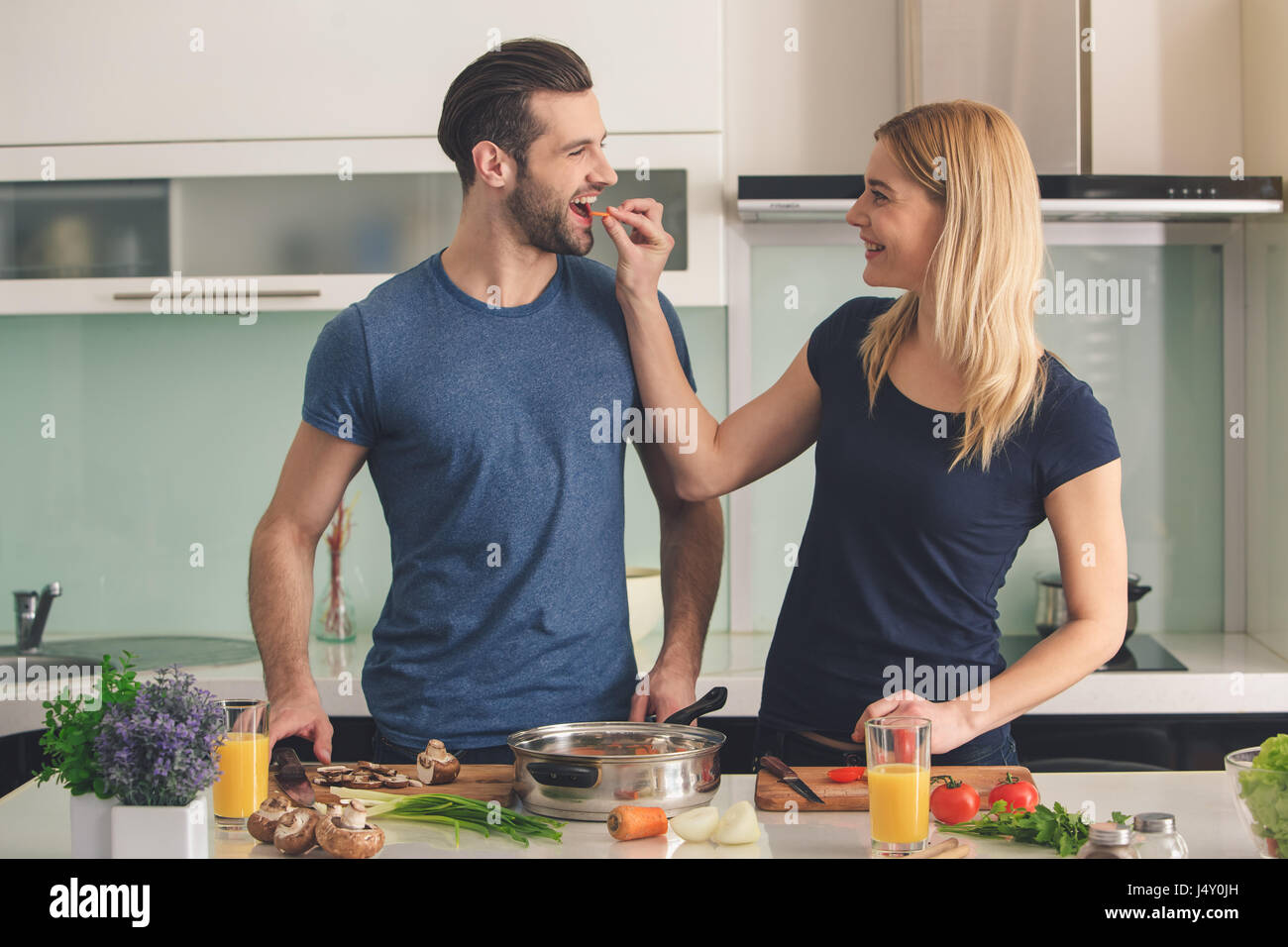Young couple cooking together meal preparation indoor Stock Photo - Alamy