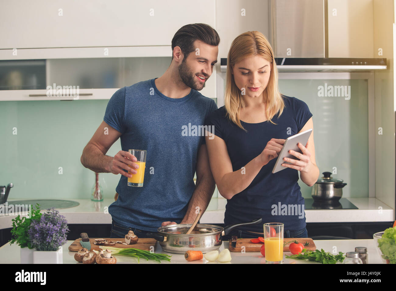 Young couple cooking together meal preparation indoor Stock Photo - Alamy