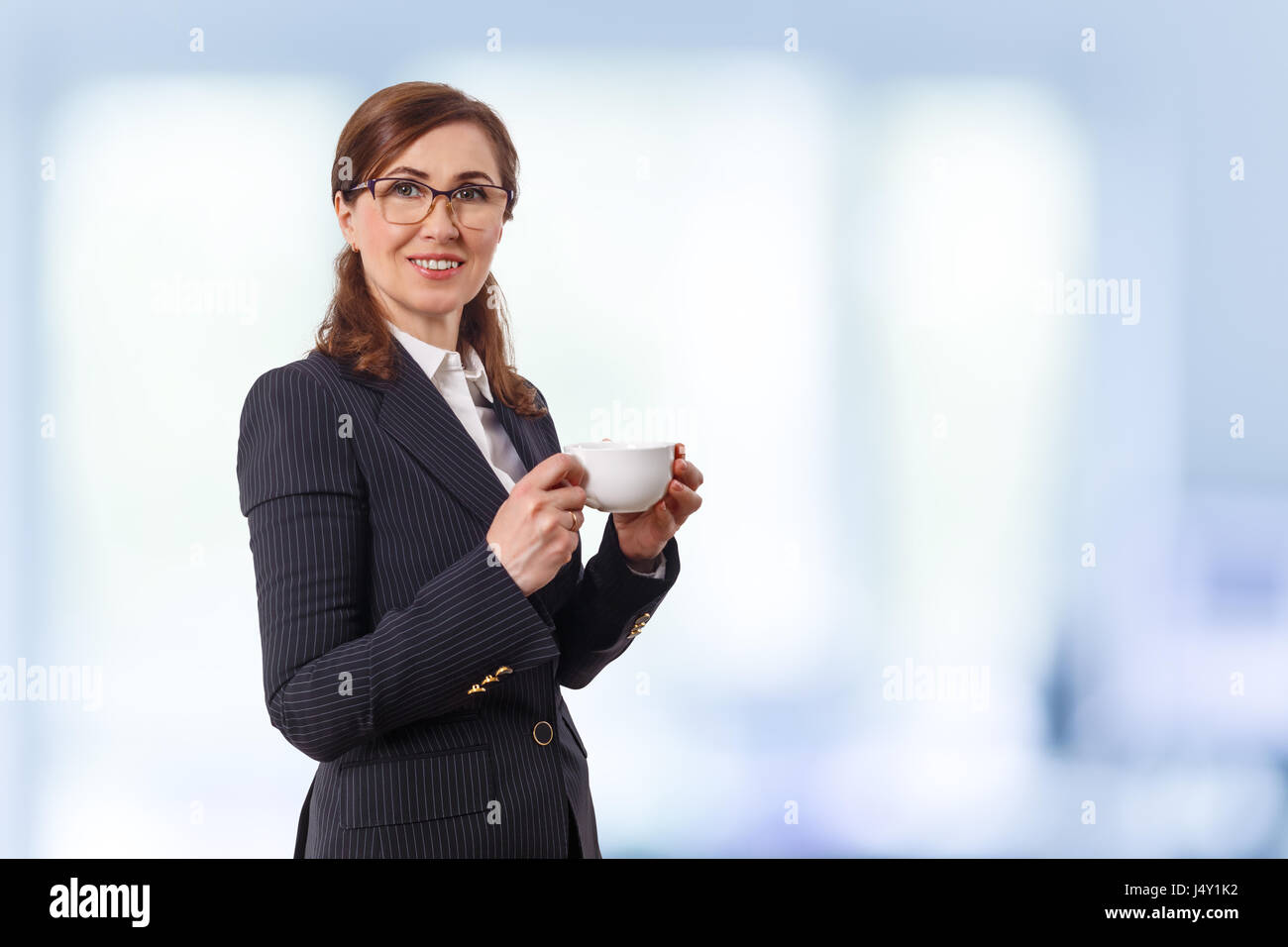 Portrait of a beautiful businesswoman 50 ears old with cup of coffee in the office. Stock Photo