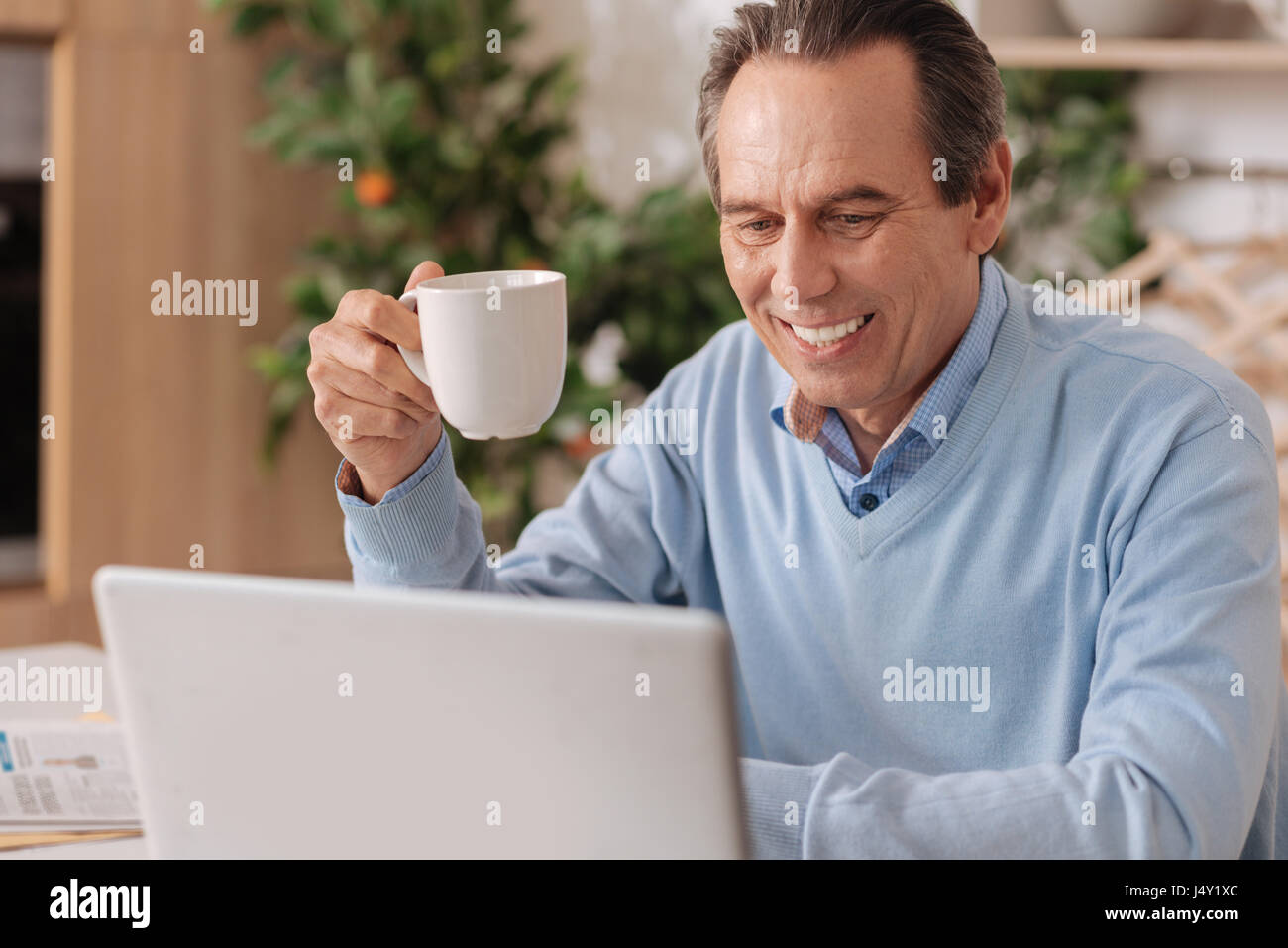 Happy retired man using electronic gadget at home Stock Photo