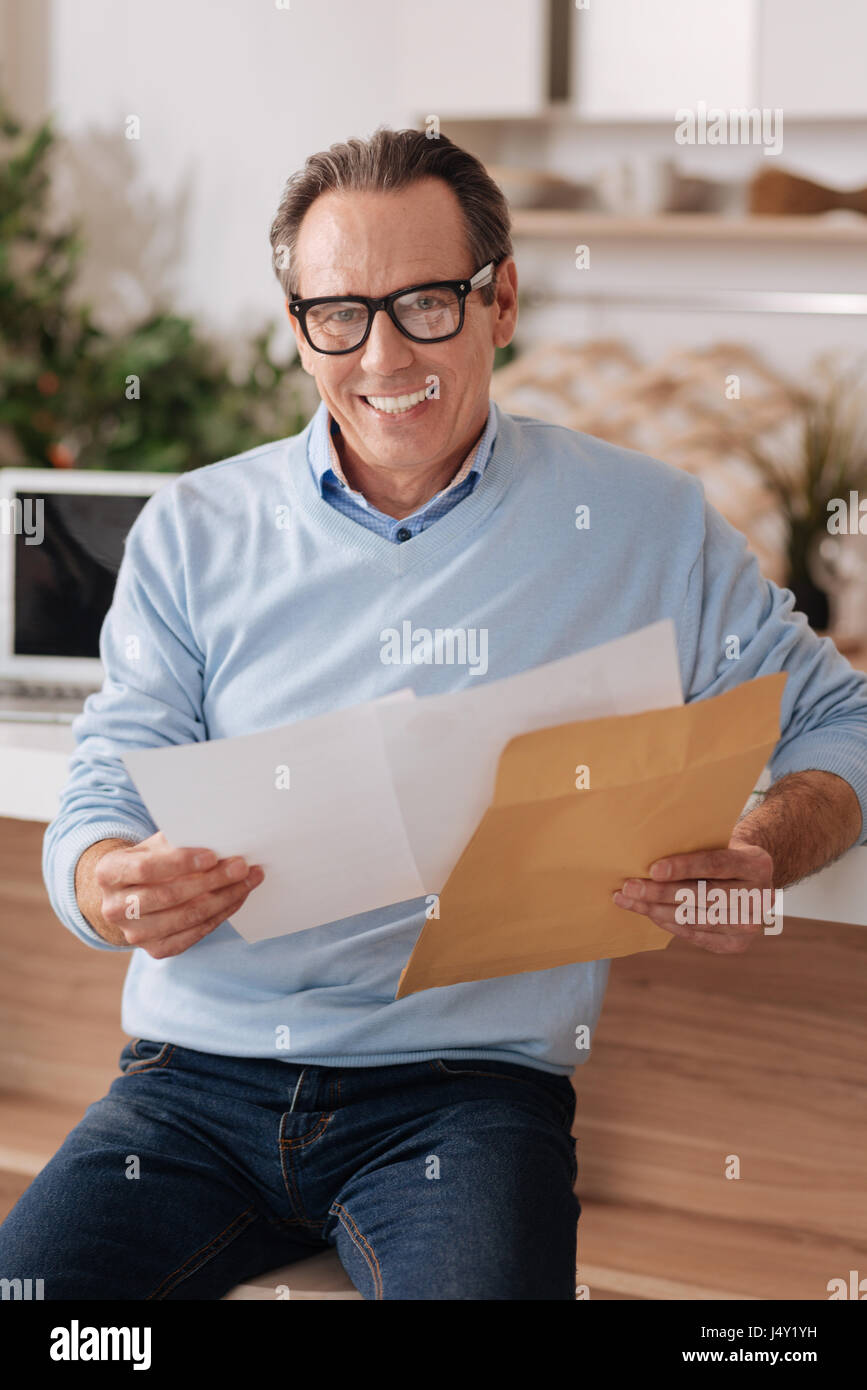 Aging happy freelancer checking post at home Stock Photo