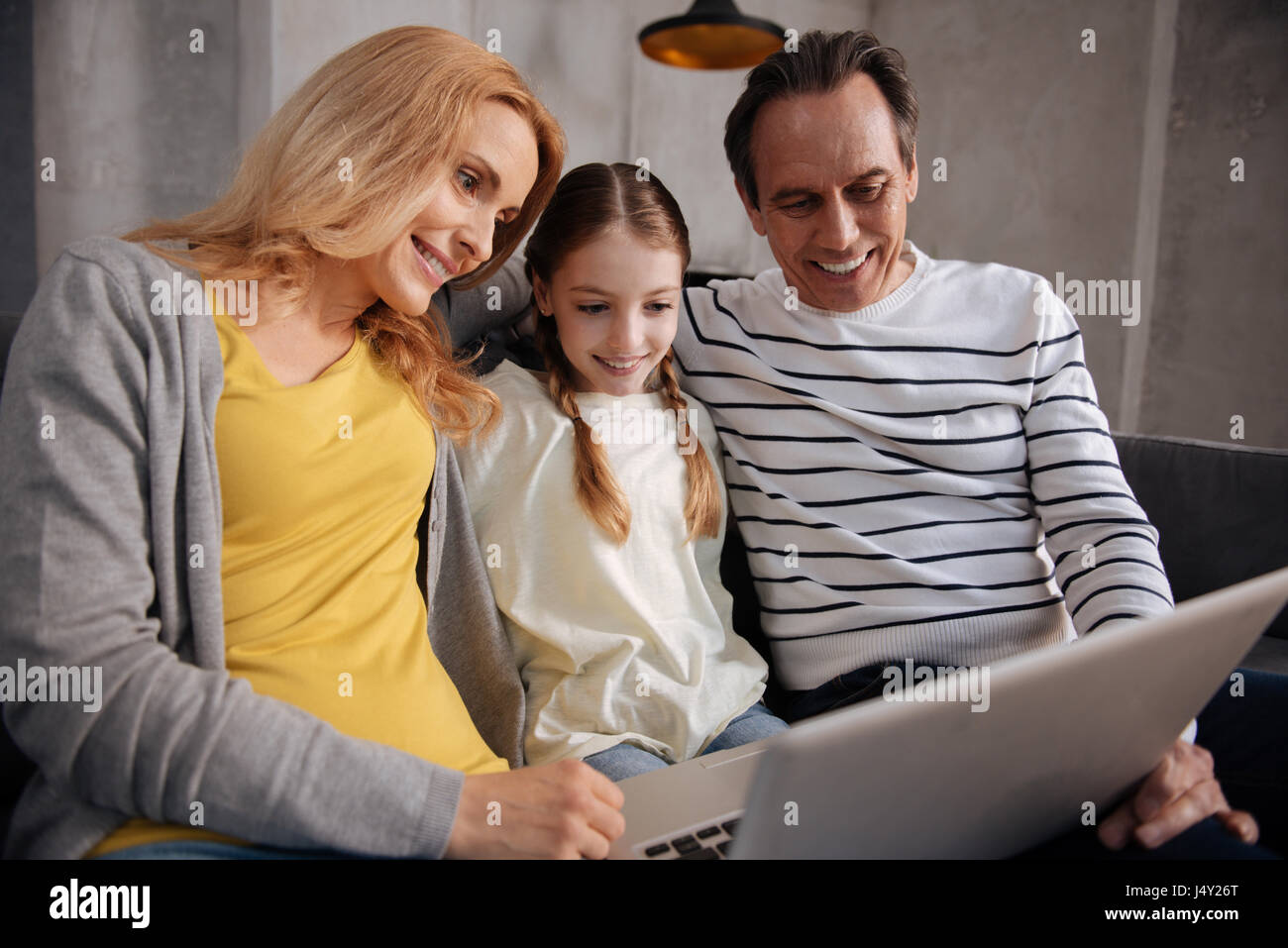 Amused family using laptop at home Stock Photo