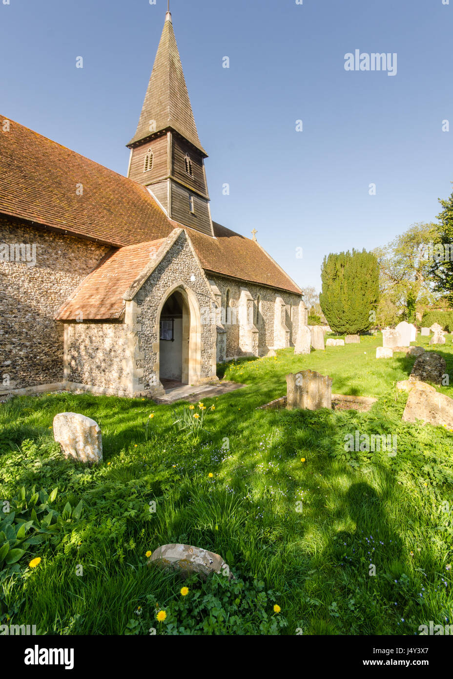 Thame, England, UK - April 18, 2015: Spring sunshine on the church, spire and graveyard of St Mary's Church in Sydenham, near Thame, Oxfordshire. Stock Photo