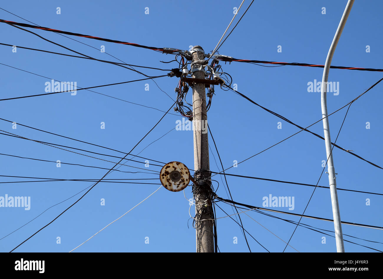 A tangle of electricity and communications cables, television aerials in Kavaje, Albania on October 01, 2016. Stock Photo