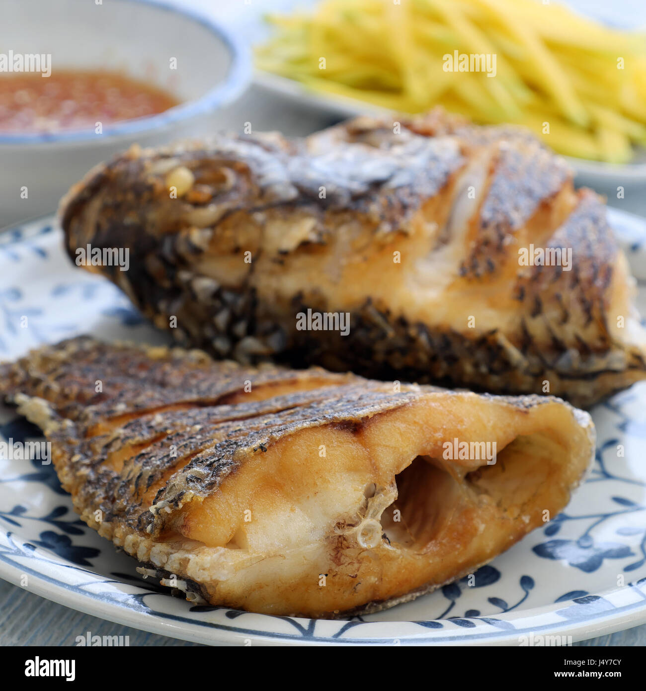 Vietnamese food for daily meal, fried fish with mango and fish sauce