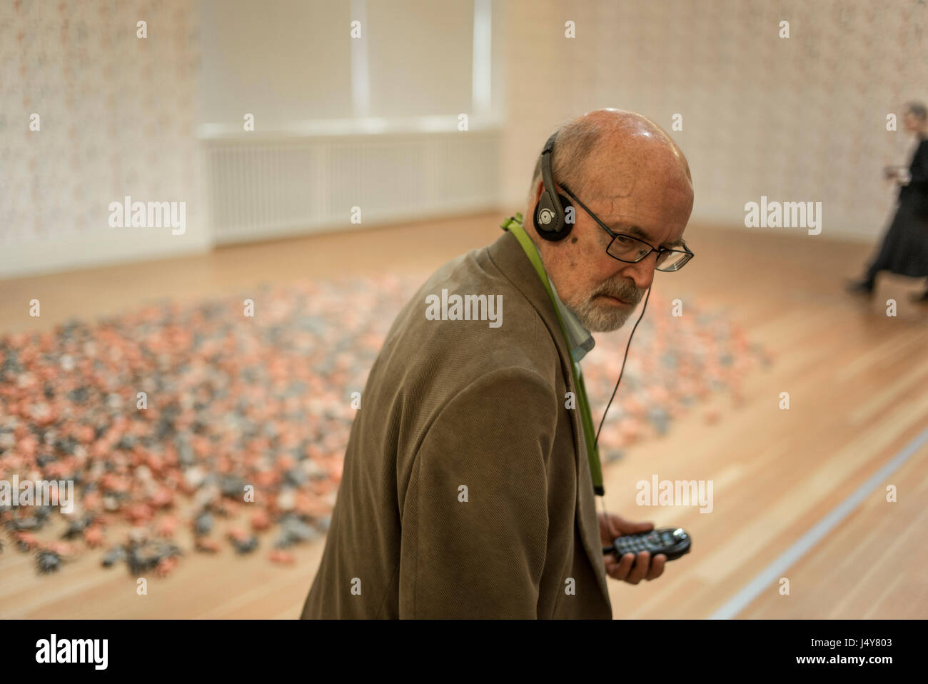 An elderly man wearing museum commentary headphones at Chinese artist Ai Wewei's 'Evidence' exhibition at the Martin Gropius-Bau, Berlin in 2015.Derek Stock Photo