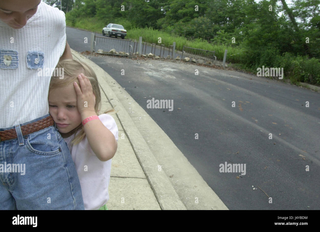 Elizabeth Wegener, 11, hugs her little sister Sarah, 5, near a road barricade erected be angry environmental activists. The road is scheduled to be extended though the woods where activists have been staging the Bluebird treesit since March to in an effort to stop the Canterbury Apartments development which the Monroe County Council approved a bond for last week.To stop a low income housing division from being built on land filled with trees and sinkhole a tree sit began during March 2001 and lasted more than 100 days in Bloomington, Indiana. The first sitter Tracy 'Dolphin' McNeely secretly c Stock Photo