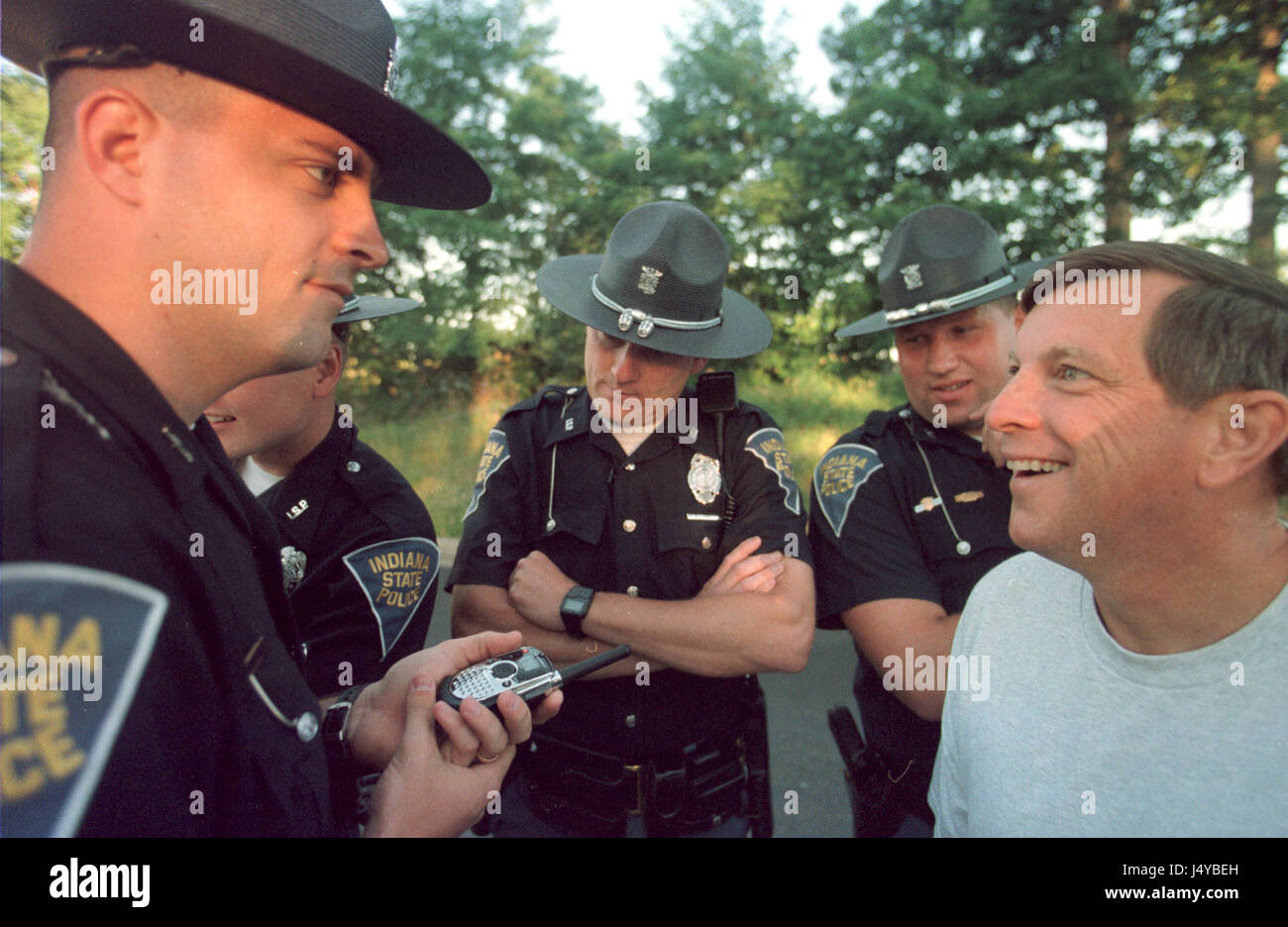 Indiana State Police listen to treesitters on the same twoway radio frequencies the sitters were using as authorities moved in to arrest them July 6, 2001. To stop a low income housing division from being built on land filled with trees and sinkhole a tree sit began during March 2001 and lasted more than 100 days in Bloomington, Indiana. The first sitter Tracy 'Dolphin' McNeely secretly climbed down in in late June citing burnout after she was supported by a ground crew for months. Another sitter, Mike 'Moss' Englert, who had replaced her managed to avoid being arrested when waw enforcement au Stock Photo
