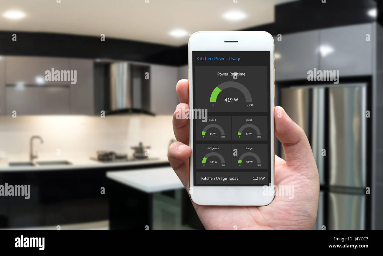 Internet of things , iot , smart home , kitchen and network connect concept. Human hand holding white phone and smart home application to count power  Stock Photo