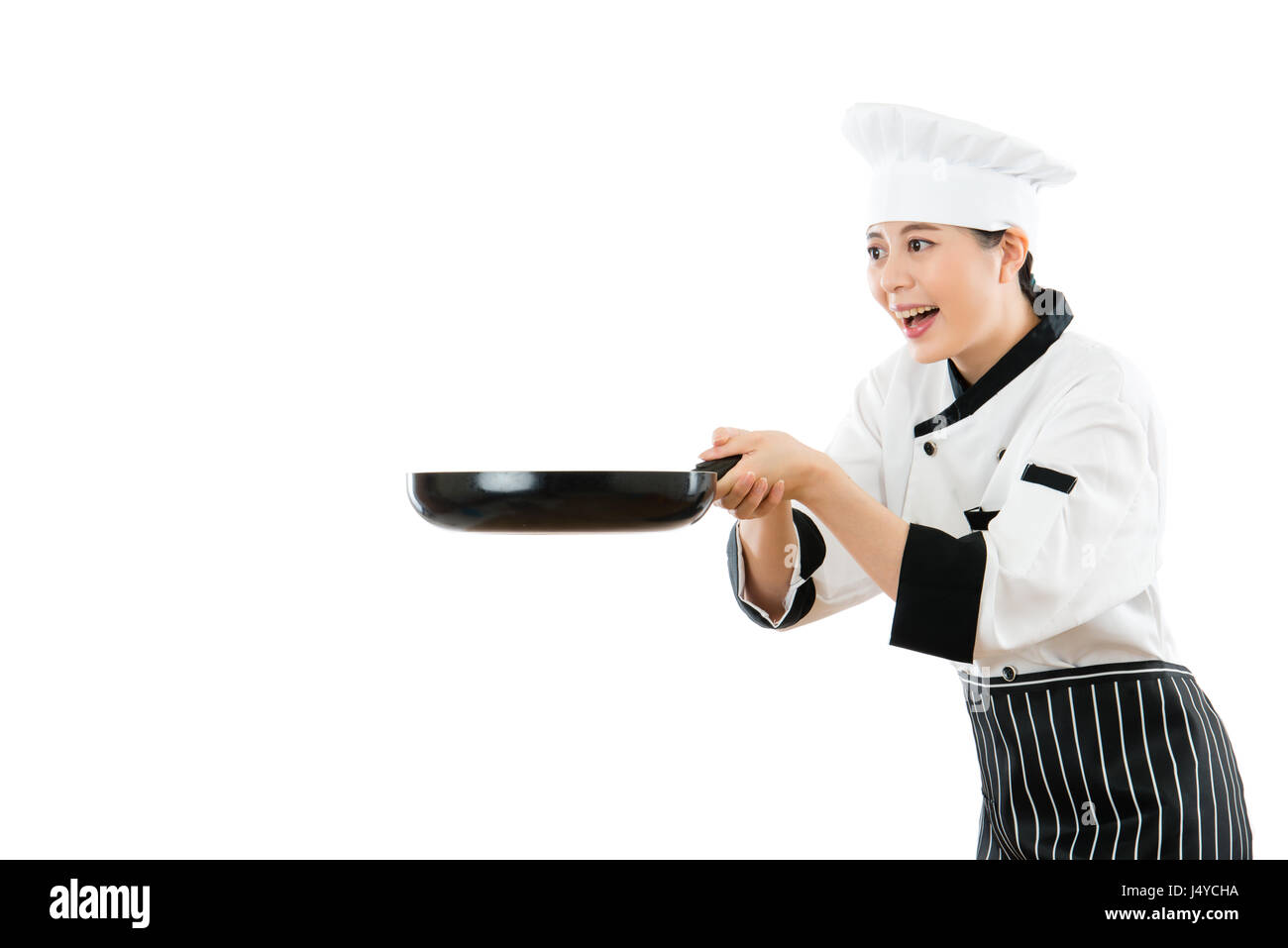 asian woman chef holding black pantry happy to catch the copyspace things and looking closely in the air standing on white wall background of advertis Stock Photo