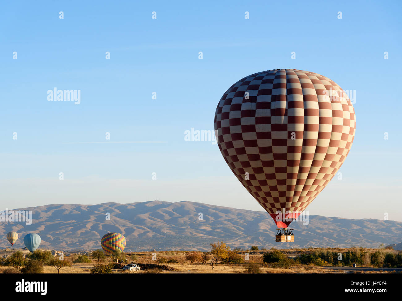 Hot air balloons landing after flight over valley of Cappadocia in the morning. Nevsehir Province. Turkey. Stock Photo