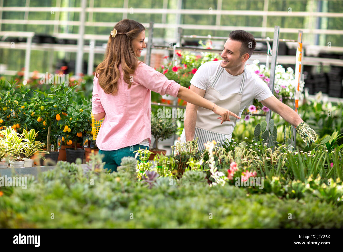 Employer surrounded by plant in greenhouse Stock Photo