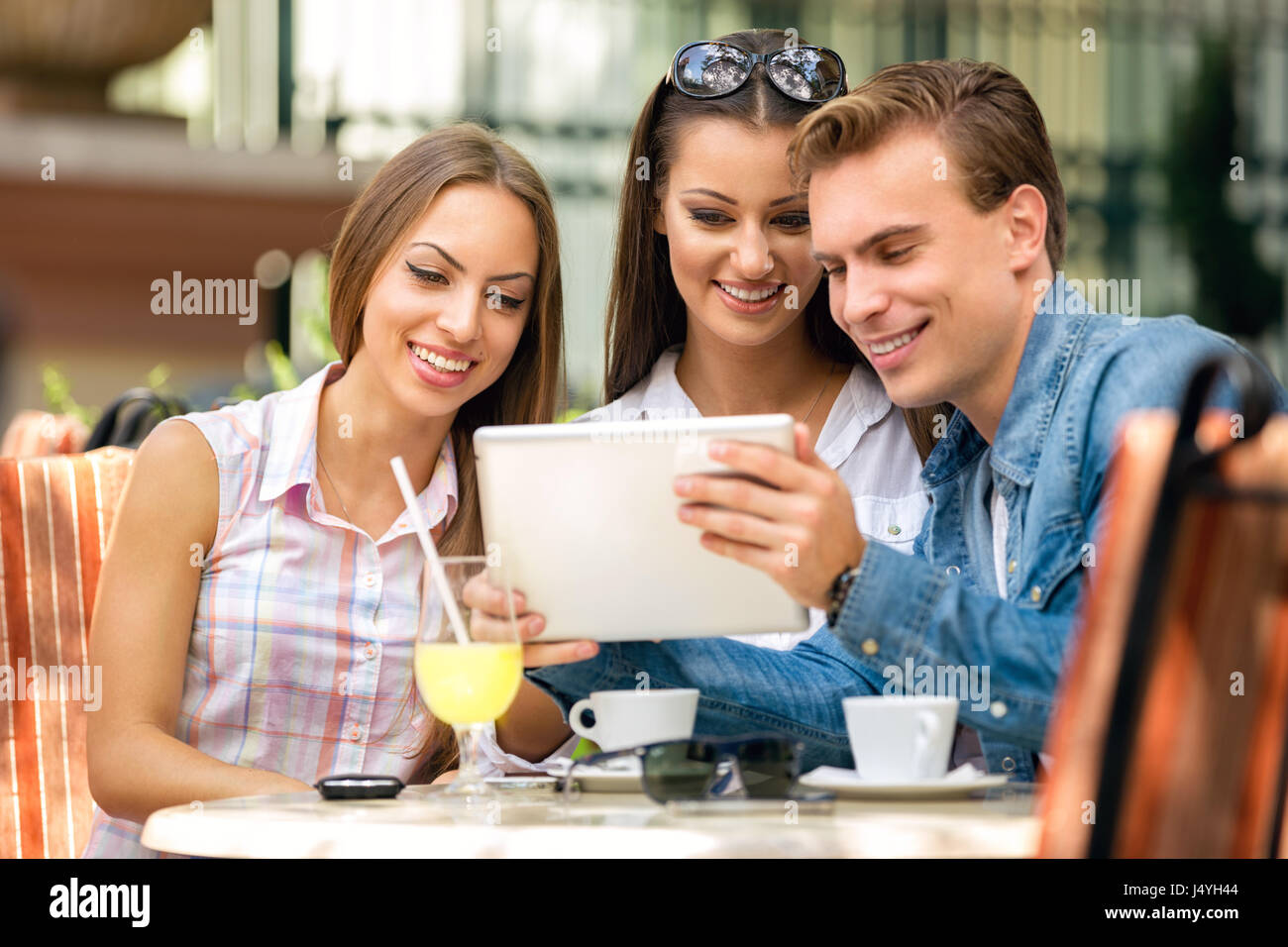 friends or colleagues enjoying leisure time in a cafe, drinking coffee Stock Photo