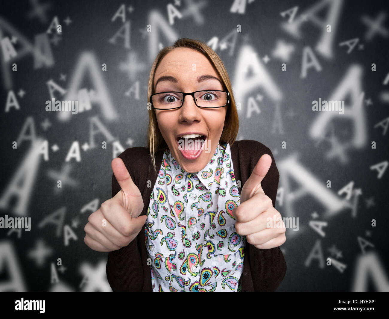 Happy nerd girl showing thumbs up with A grades on background Stock