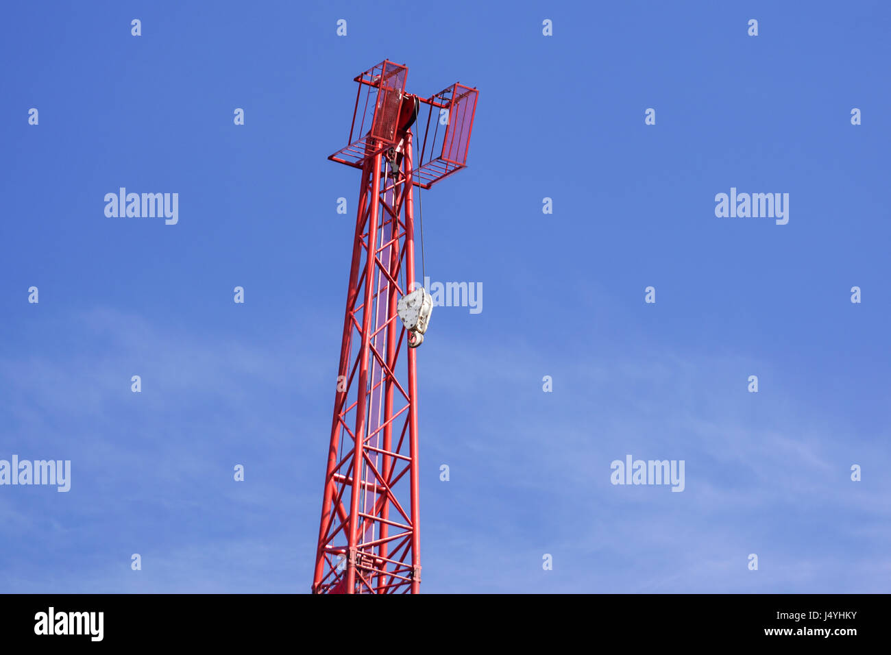 Red industrial construction crane against blue sky Stock Photo