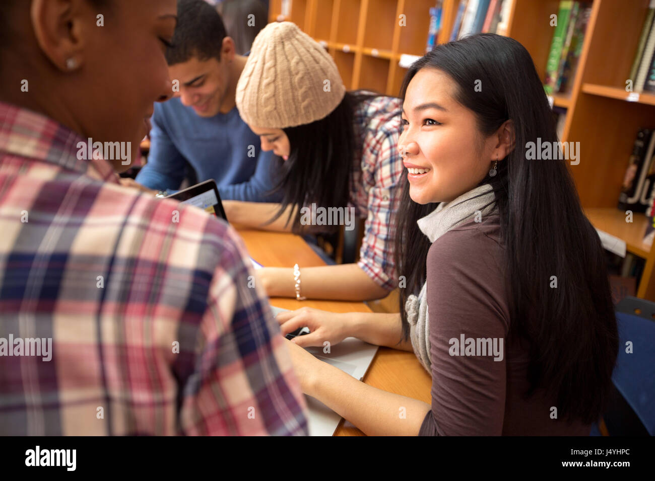 Studding friends socializing and studying together in library Stock Photo