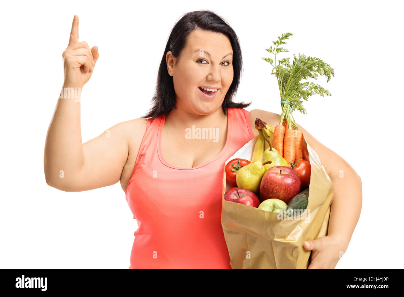 Happy overweight woman with a paper bag filled with groceries holding her finger up isolated on white background Stock Photo