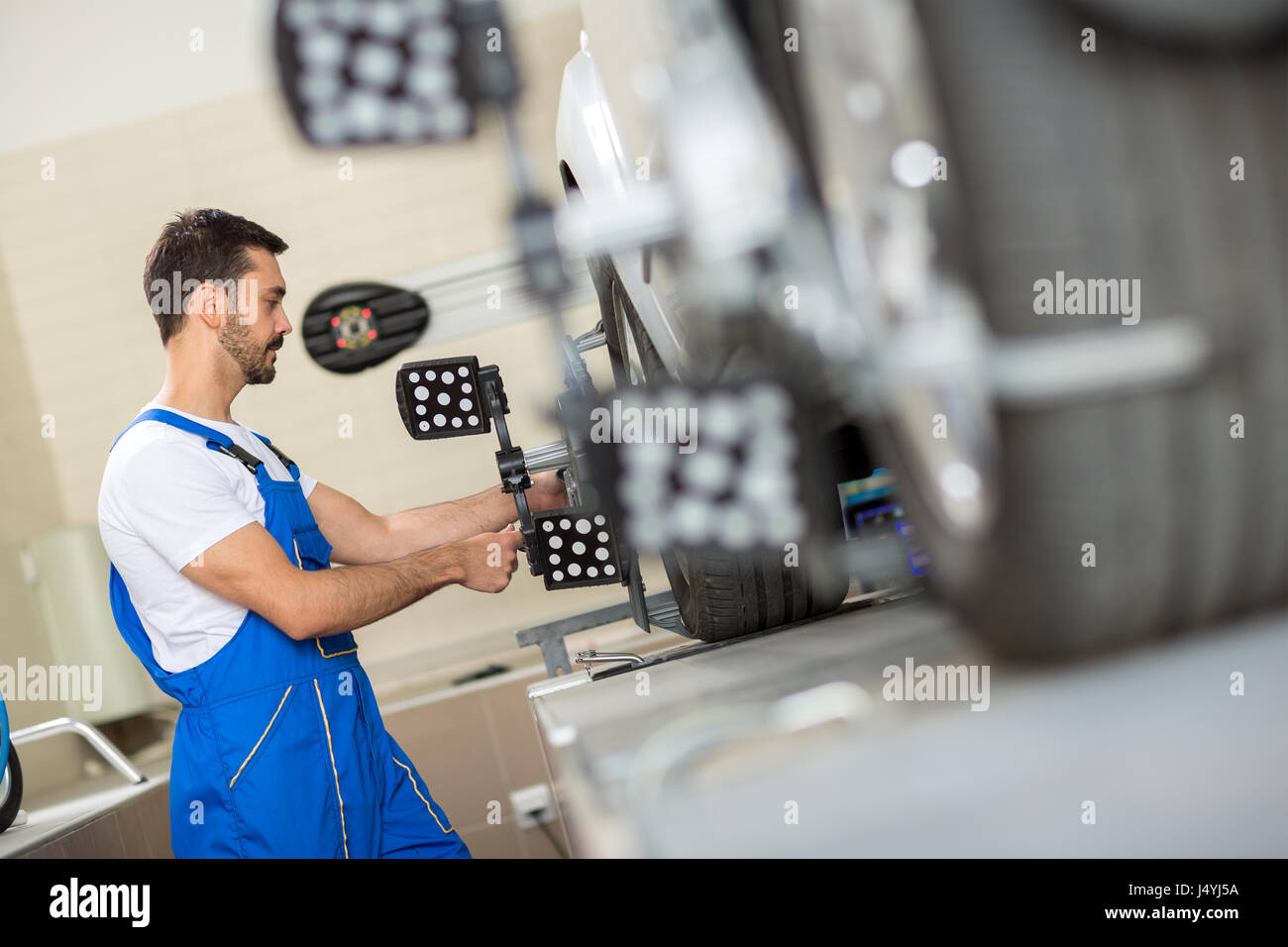 car mechanic installing sensor during suspension adjustment Stock Photo