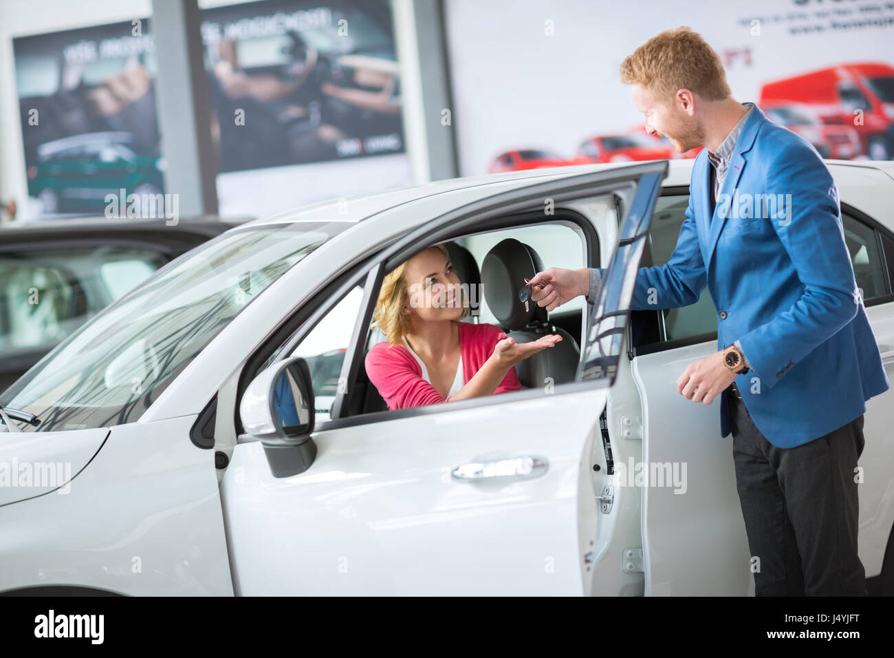 Sales manager giving key from the new car female client Stock Photo - Alamy