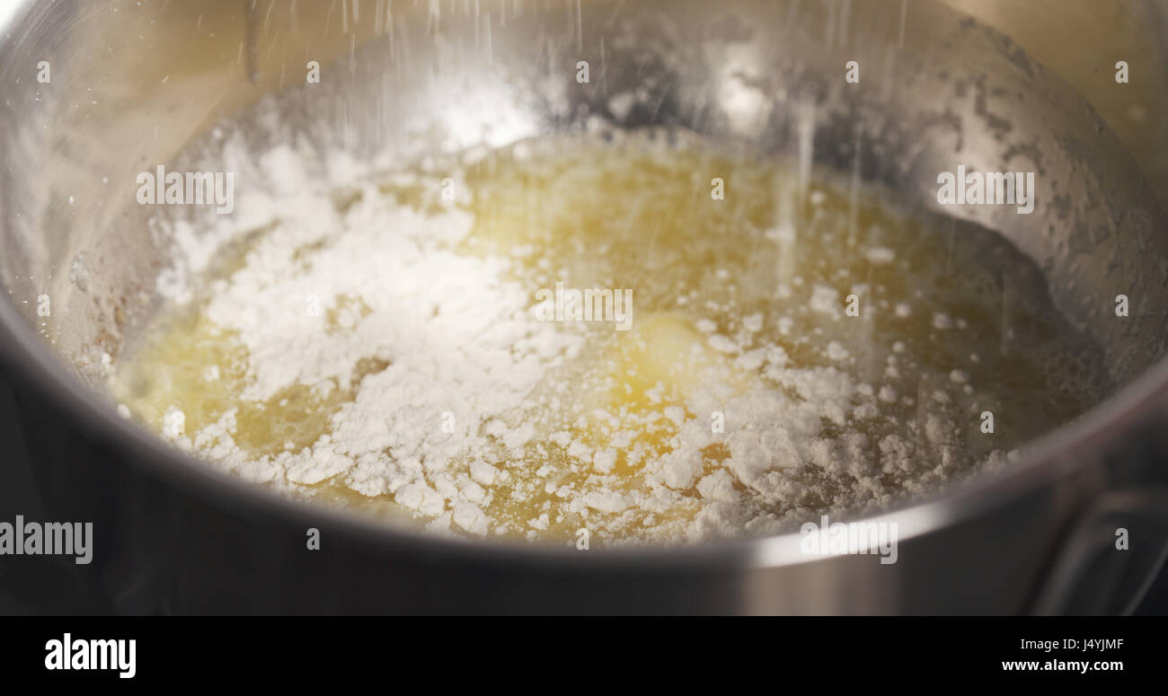 preparing bechamel sauce adding flour Stock Photo Alamy