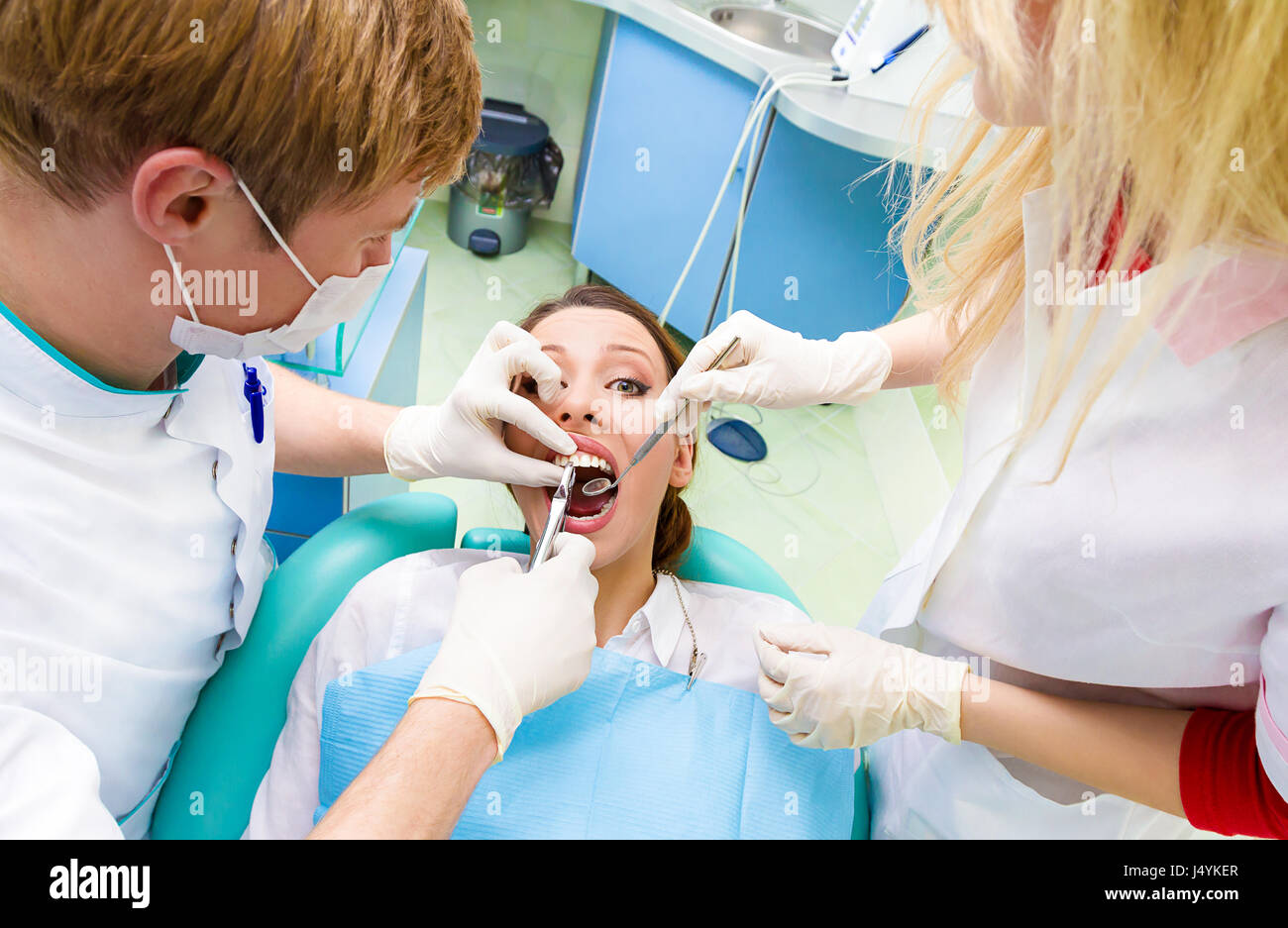 Closeup portrait dentist, his assistant carrying out thorough