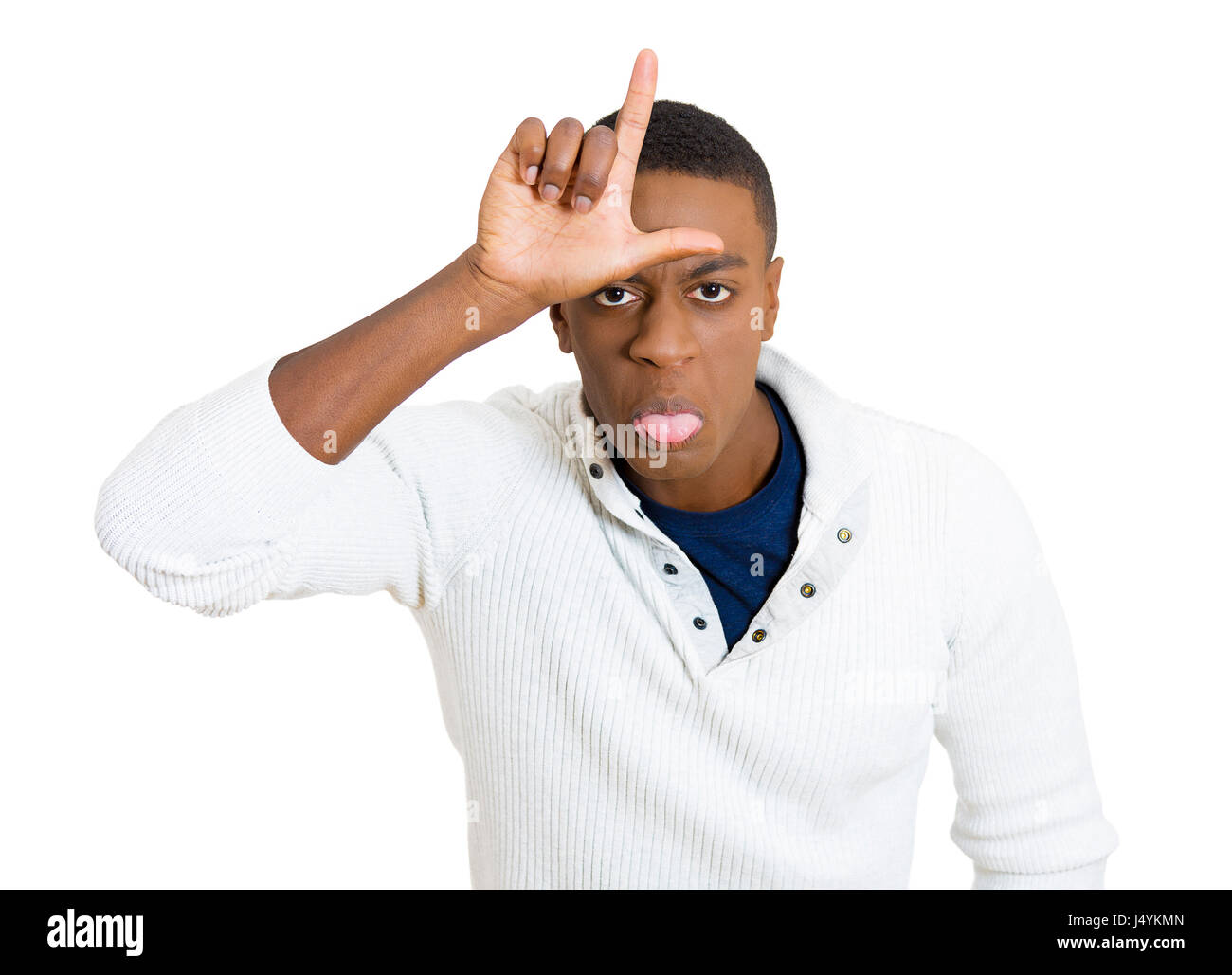 Closeup portrait, funny young man showing loser sign on his forehead