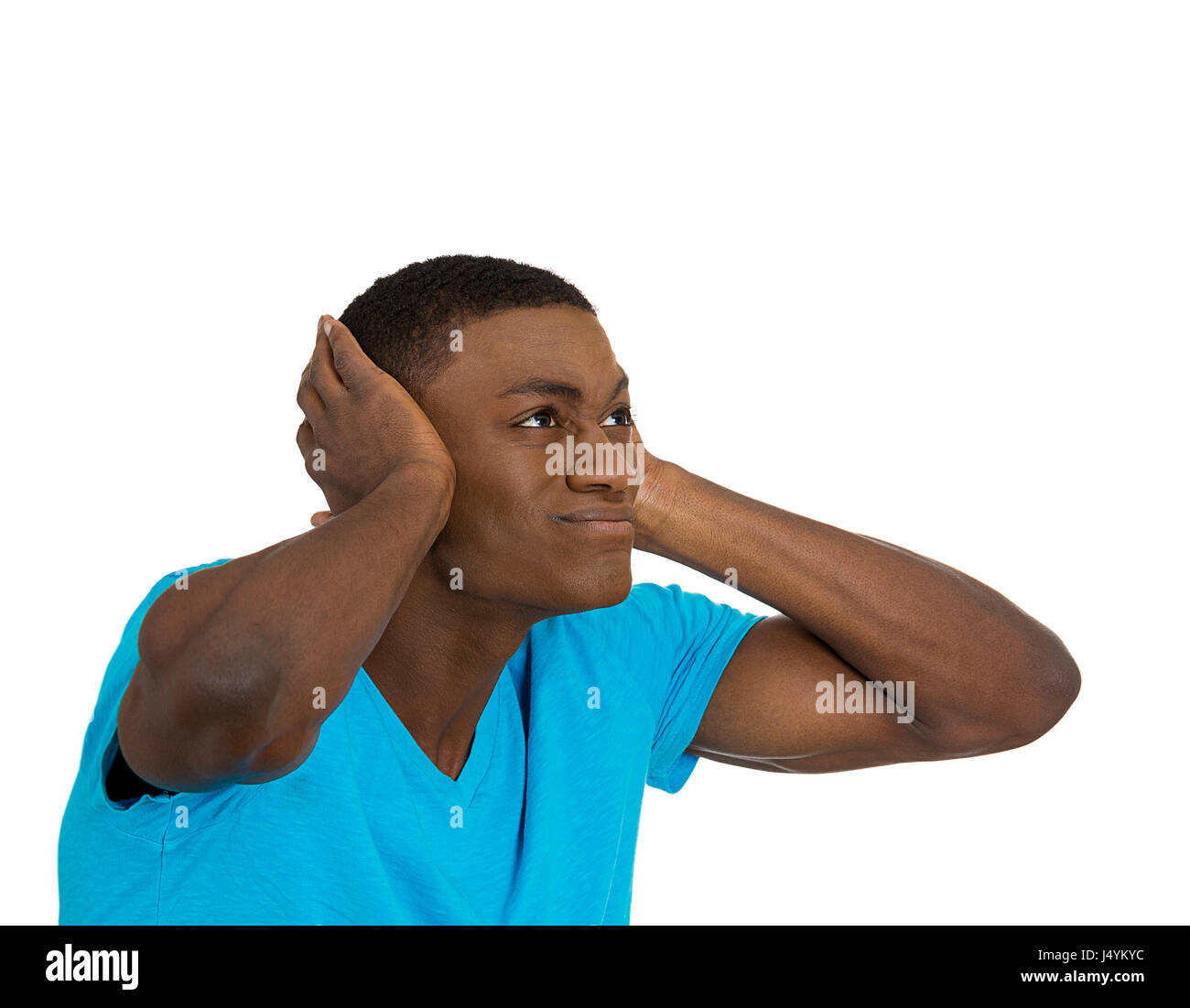 Closeup portrait young angry mad unhappy stressed man covering his ears