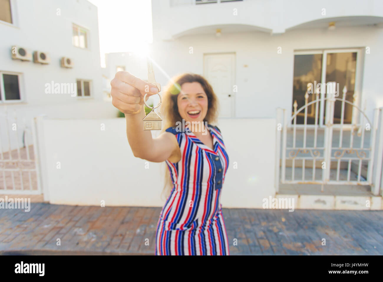 Happy young woman In Front of New Home with New House Keys Stock Photo ...