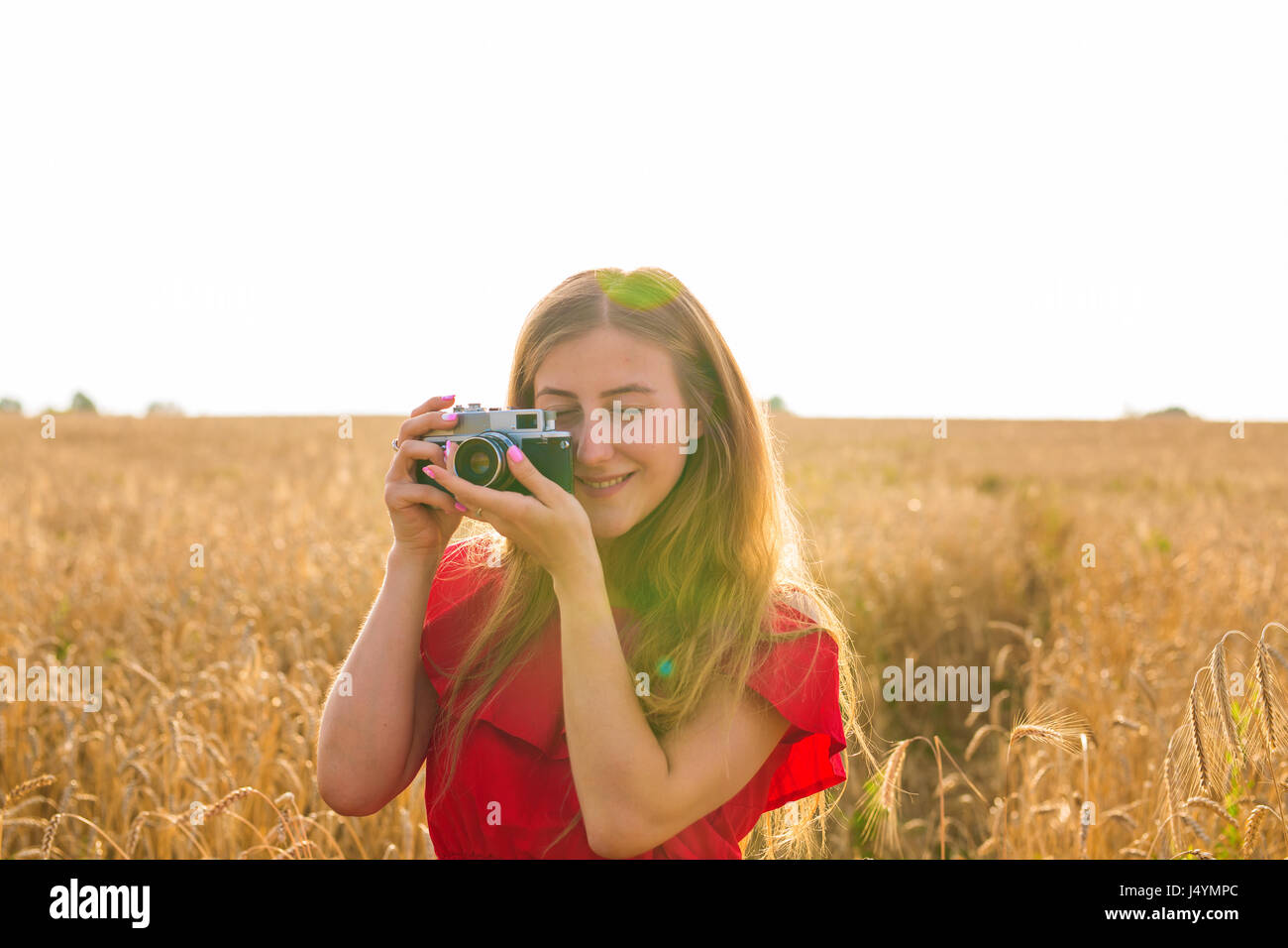 Young woman in the field with vintage camera Stock Photo - Alamy