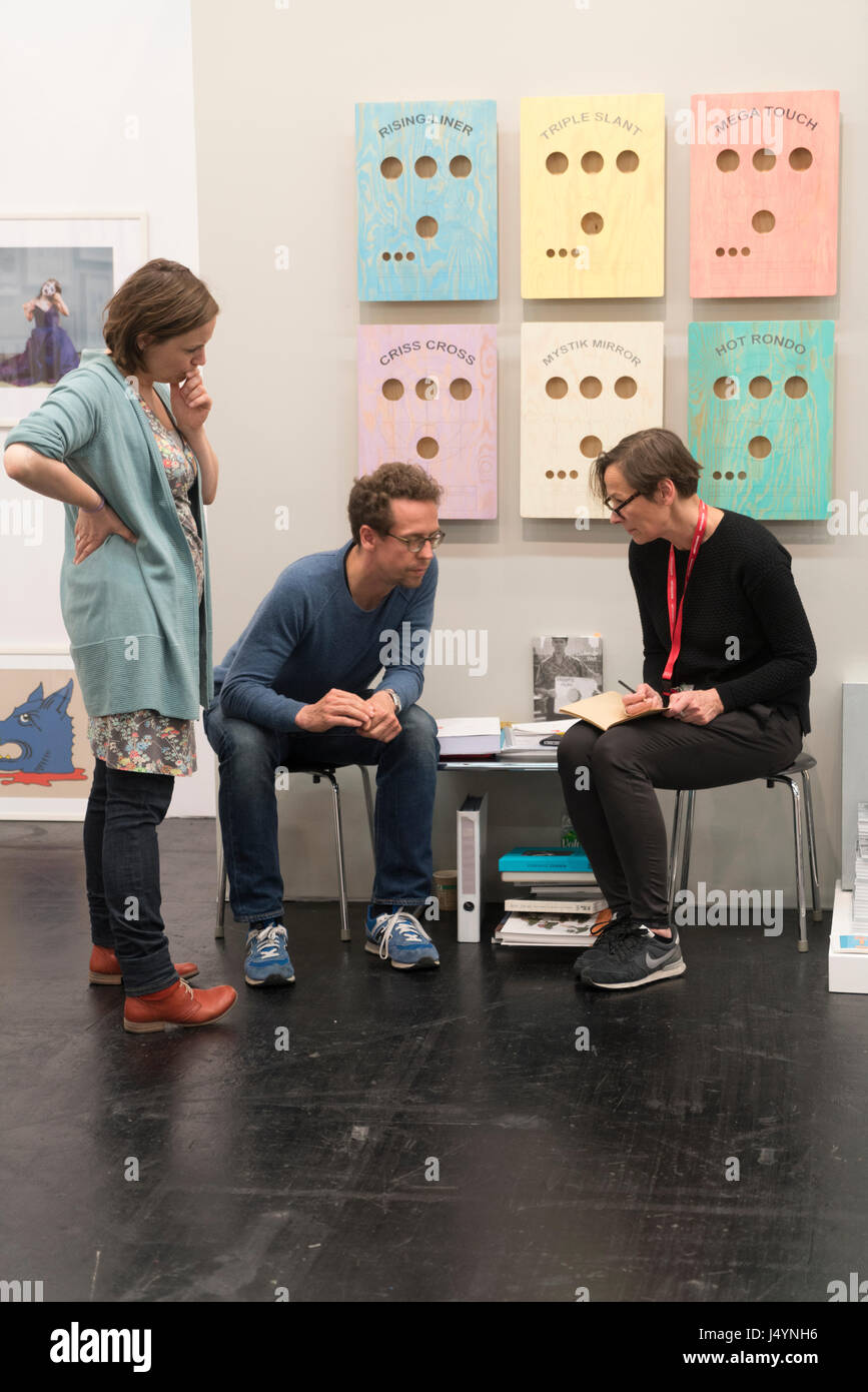 A sales representativ in a talk with interested people at ART COLOGNE. Stock Photo