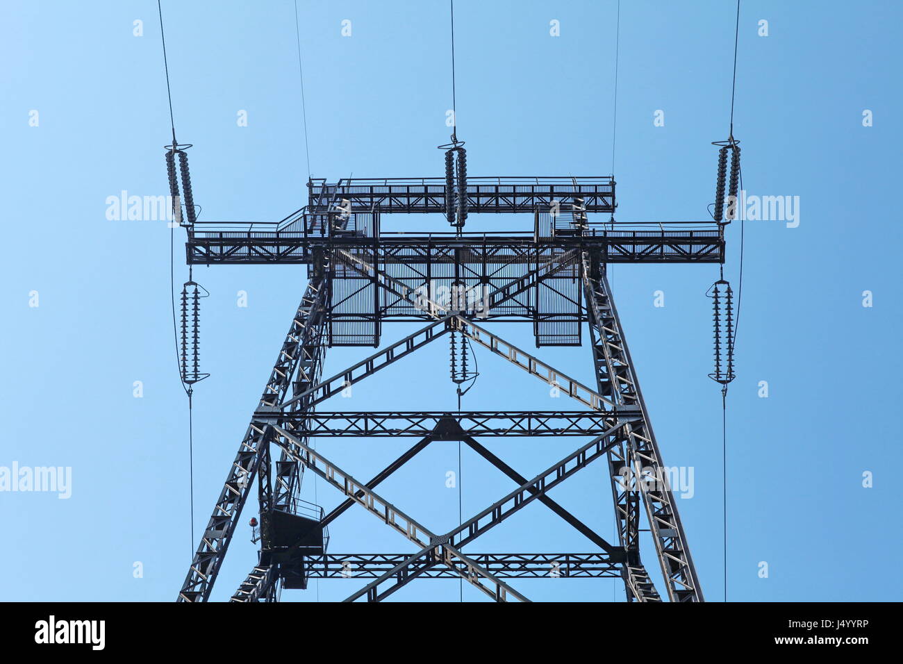 Power lines and electricity pylon against blue sky Stock Photo - Alamy