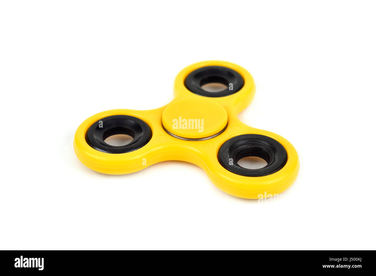a yellow fidget spinner on a white background Stock Photo - Alamy