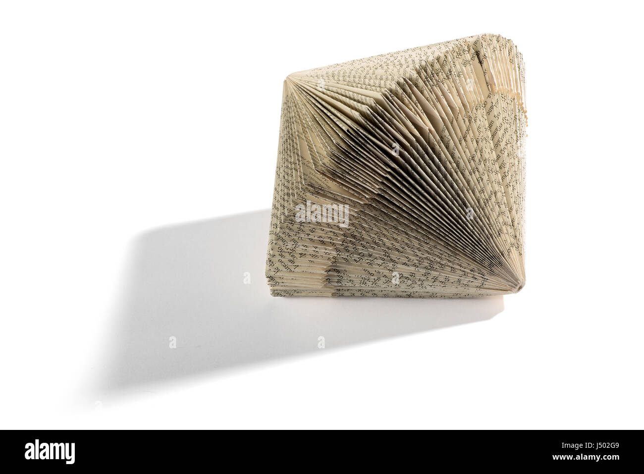 Ornamental geometrical concertina book shape with printed paper lying on its side on a white background with shadow and copy space Stock Photo