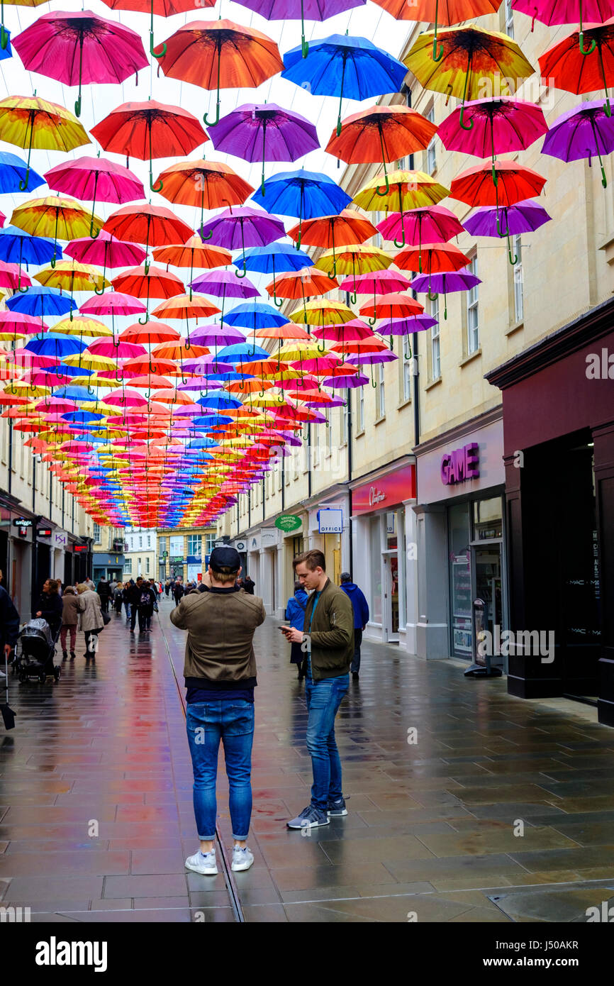 Bath, UK. 15th May, 2017. UK Weather. A drizzly wet day in Bath. Shoppers stop to look at the timely installation of colourful umbrellas. Credit: Mr Standfast/Alamy Live News Stock Photo