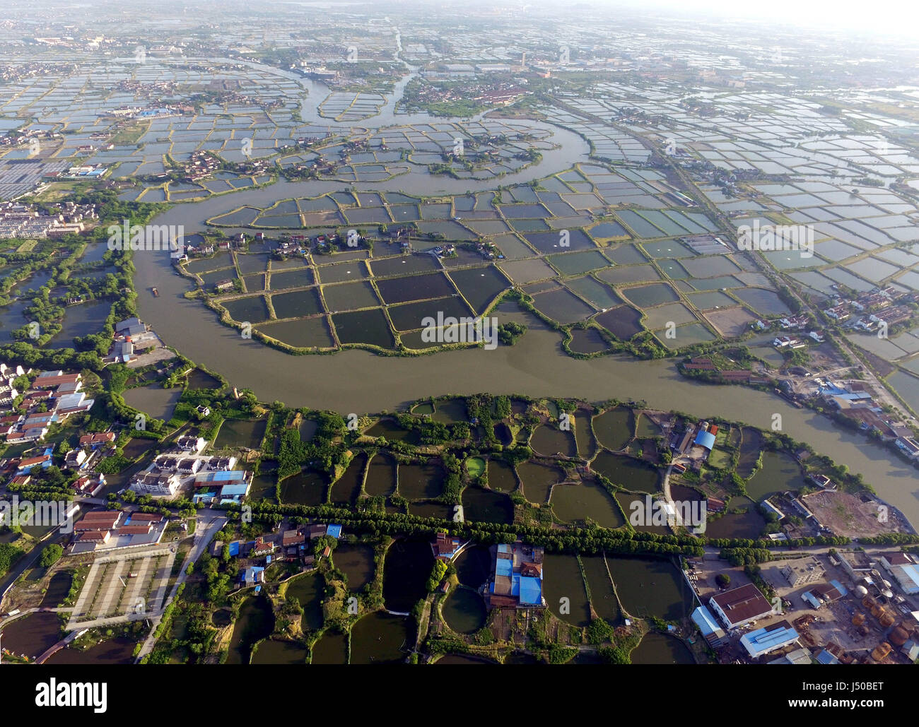 Huzhou. 13th May, 2017. Aerial photo taken on May 13, 2017 shows mulberry fish ponds in Nanxun District, Huzhou City of east China's Zhejiang Province. Mulberry fish pond is a special dike-pond mode, integrated fish ponds with breeding of mulberry silkworm. Credit: Wang Dingchang/Xinhua/Alamy Live News Stock Photo