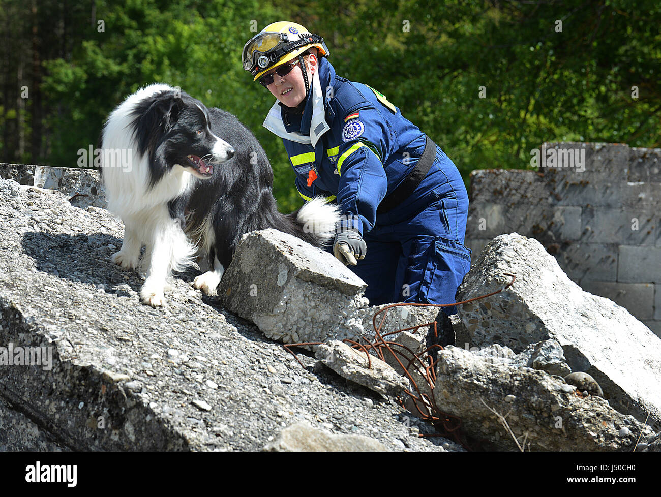 Geneva, Switzerland. 8th May, 2017. International drill 'ACHILLES 2017': Volunteer Monique Biver-Kirsch and her dog Robin of the German Federal Agency for Technical Relief (THW) demonstrates how to search with dogs for injured or spilled persons in a destroyed building after an earthquake drill in Epeisses near Geneva, Switzerland, 8 May 2017. | usage worldwide Credit: dpa/Alamy Live News Stock Photo