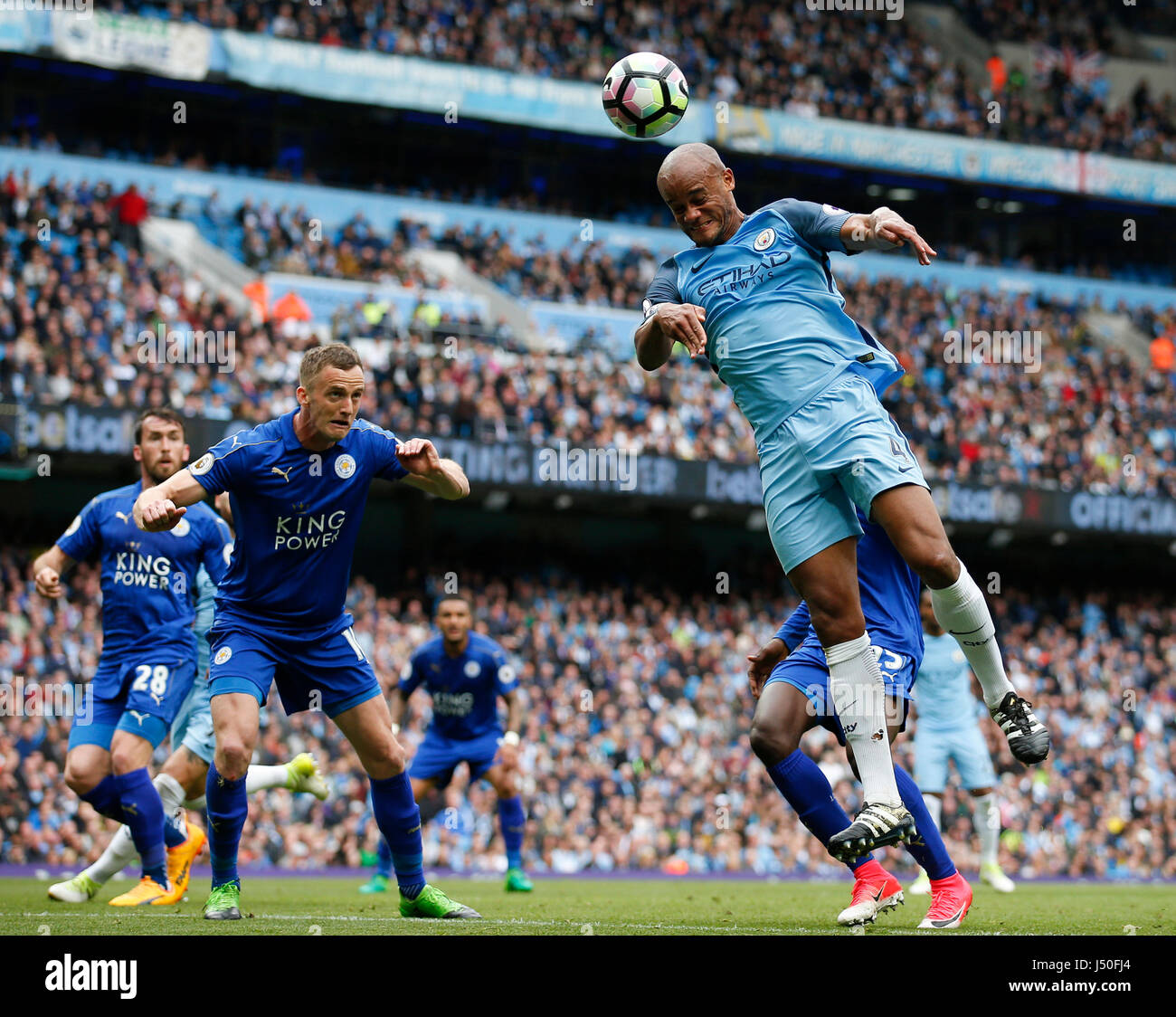 Manchester, UK. 13th May, 2017. Vincent Kompany of Manchester City climbs to try and connect with a header as Andy King of Leicester City waits to clear during the English Premier League match at the Etihad Stadium, Manchester. Picture date: May 13th 2017. Pic credit should read: Simon Bellis/Sportimage/CSM/Alamy Live News Stock Photo