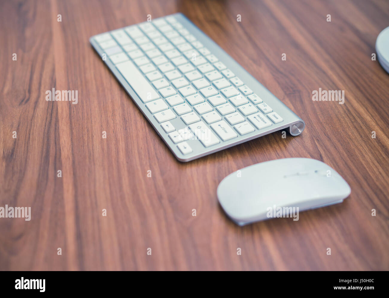 White wireless keyboard and wireless mouse on the wooden table Stock Photo