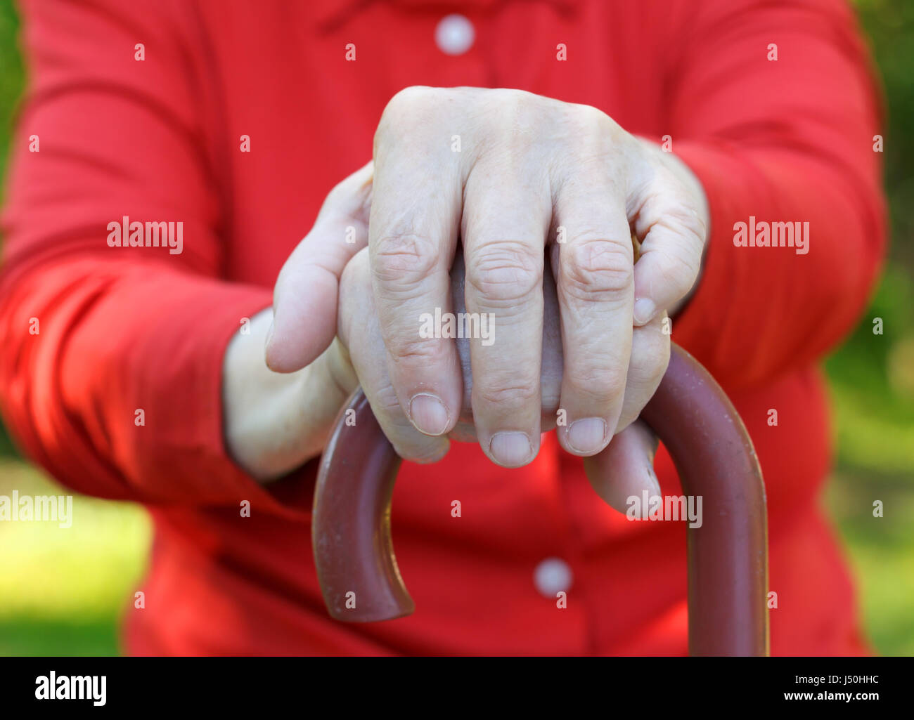 Close up of an elderly hand holding a cane Stock Photo