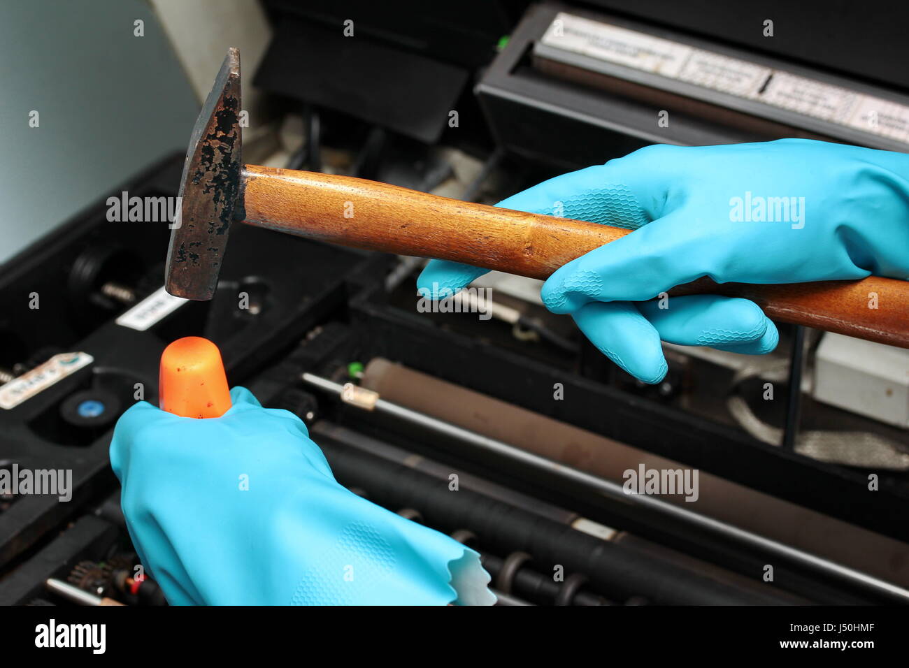 Technician wear rubber grove to use hammer to hit screwdriver for