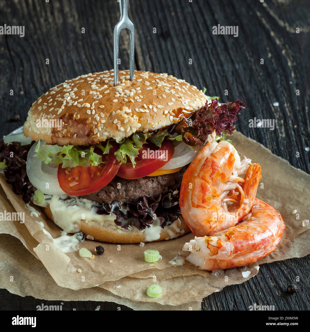 Delicious fresh homemade surf and turf  burger on wooden table Stock Photo