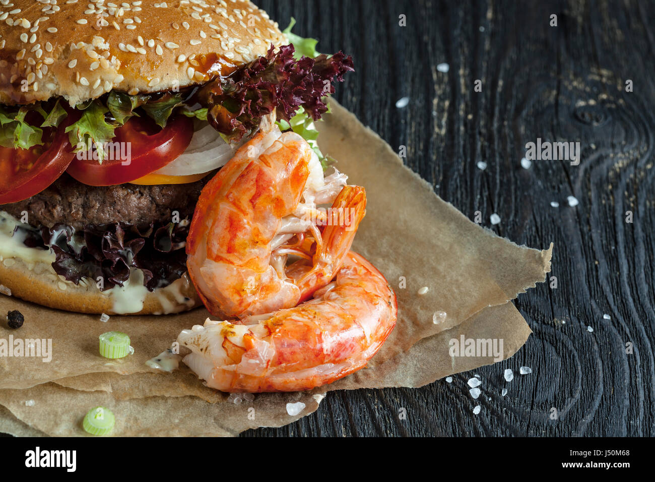 Delicious fresh homemade surf and turf  burger on wooden table Stock Photo