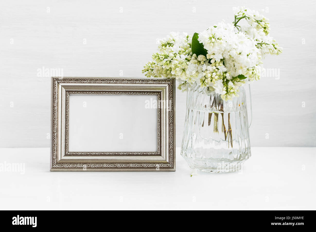 Still life with lilac bouquet vase and a vintage photo frame on clean ...