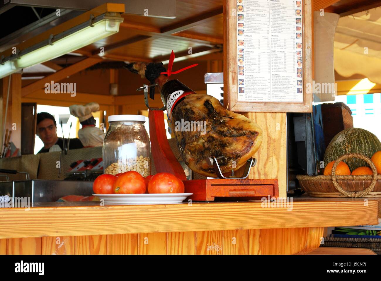 Jamon Serrano ham joint and tomatoes on a beach bar counter along the promenade, Torremolinos, Malaga Province, Andalusia, Spain, Western Europe. Stock Photo
