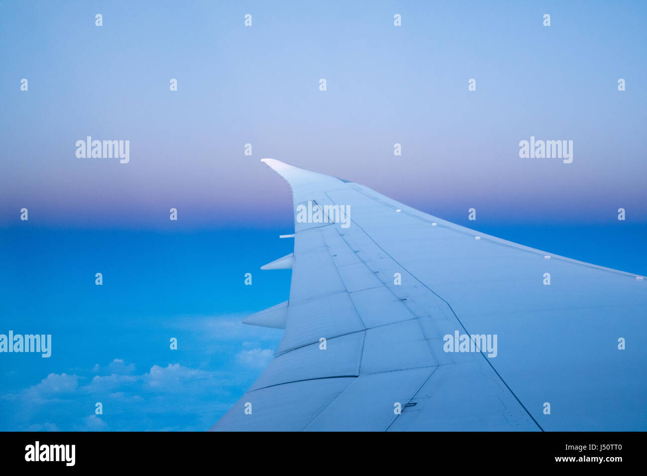 wing of an airplane flying above the clouds Stock Photo - Alamy