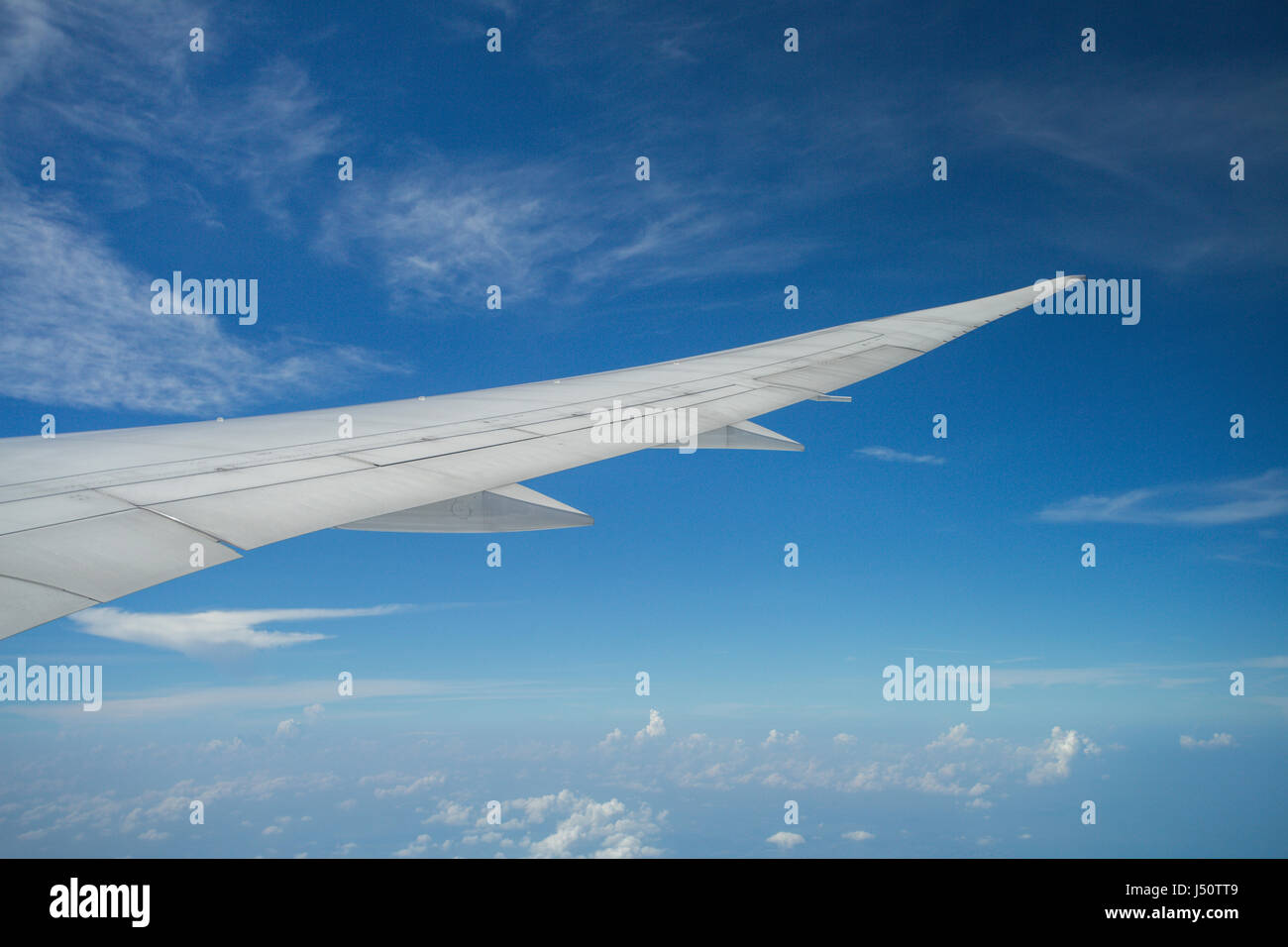 wing of an airplane flying above the clouds Stock Photo - Alamy