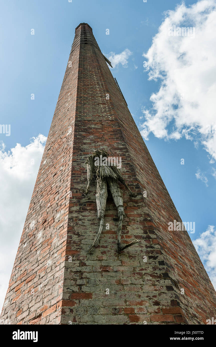 Derelict mill chimney and straw man Stock Photo
